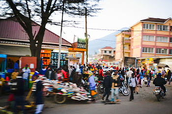 Bustling street market in Arusha, Tanzania with diverse crowd, shops, and vibrant urban life. HD wallpaper