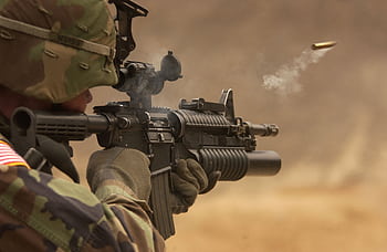 Close-up of a soldier in camo firing a rifle in action during training. HD wallpaper