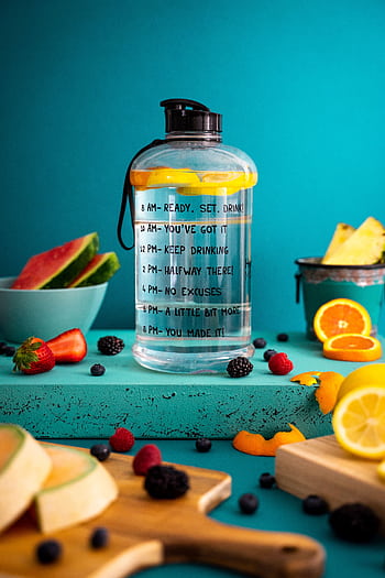 Bright composition of mixed fruits around a motivational water bottle indoors. HD phone wallpaper