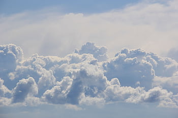 Blue sky with soft, fluffy clouds creating a tranquil and airy atmosphere. HD wallpaper