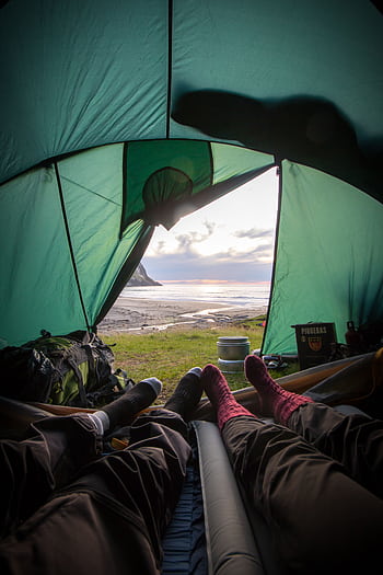 View from inside a tent overlooking a coastal sunset, capturing a relaxing camping experience. HD phone wallpaper