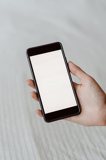 A close-up of a hand holding a smart with a blank screen, perfect for mockups. HD phone wallpaper