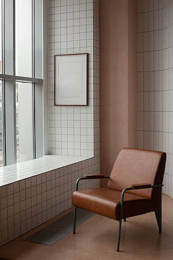 Stylish interior with a brown leather armchair in a bright, modern setting by a window. HD phone wallpaper