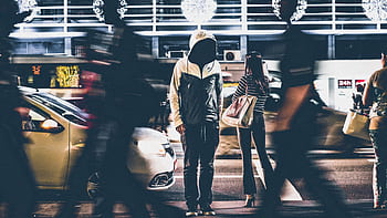 Dynamic night street scene capturing people and cars in motion blur. HD wallpaper
