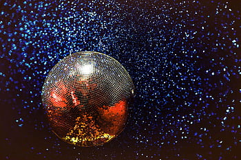 Shining disco ball with colorful reflections in a dark, starry background. HD wallpaper