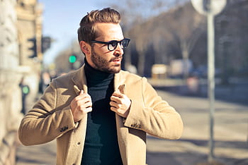 Fashionable young man with sunglasses poses outdoors in a sunny Budapest street scene. HD wallpaper