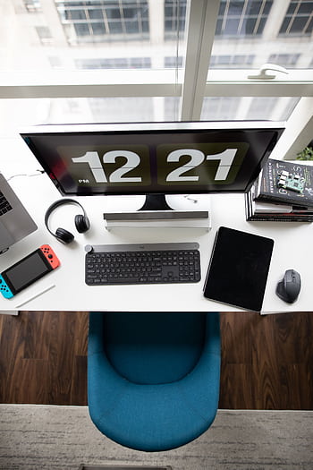 A top view of a modern desk setup featuring a computer monitor, keyboard, tablet, books, and gadgets. HD phone wallpaper
