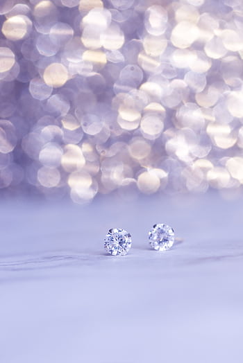 Close-up shot of sparkling diamond earrings against a beautiful bokeh background, showcasing luxury. HD phone wallpaper
