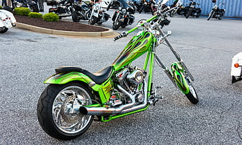 A vibrant custom green motorcycle with chrome detailing parked outdoors. HD wallpaper