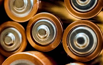 Detailed view of grouped cylindrical batteries showcasing industrial energy concepts. HD wallpaper