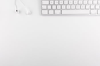 Top view of a white minimalist desk featuring a keyboard and ears, ideal for technology themes. HD wallpaper