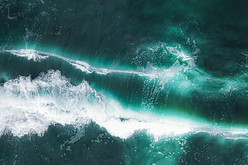 Dynamic aerial shot of turquoise ocean waves creating stunning patterns near Chukai, Malaysia. HD wallpaper