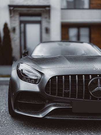 Close-up of a sleek Mercedes Benz car front, showcasing luxury design in an urban background. HD phone wallpaper