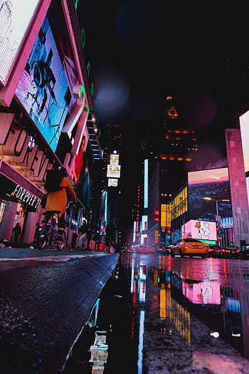 Illuminated street scene of Times Square with neon lights and reflections at night in NYC. HD phone wallpaper