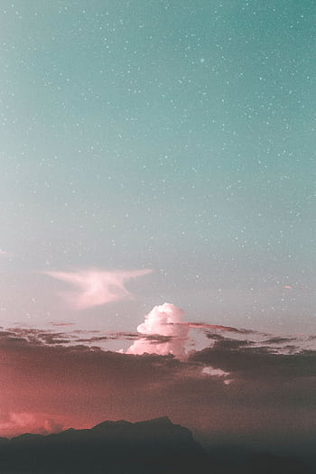 A captivating view of a starry sky with mountains and clouds at twilight, evoking a sense of tranquility. HD phone wallpaper