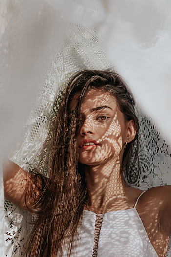 Artistic portrait of a young woman with intriguing lace shadow patterns on her face. HD phone wallpaper