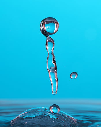 A high-speed close-up of a water droplet suspended mid-air on a blue background. HD phone wallpaper