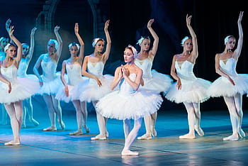 Elegant ballerinas performing Swan Lake ballet on stage in classic tutus. HD wallpaper