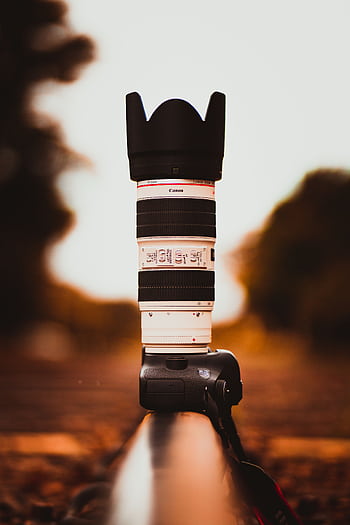 Stylish tele lens on DSLR camera placed outdoors with blurred bokeh background. HD phone wallpaper