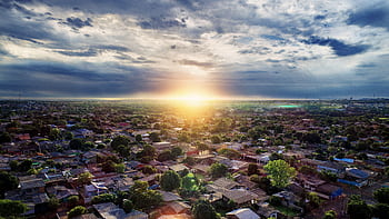Beautiful aerial shot capturing a village with houses and trees during sunrise. HD wallpaper