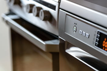 Close-up view of modern stainless steel kitchen appliances with focus on dishwasher and oven. HD wallpaper