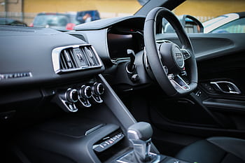 Explore the sleek interior of a modern luxury Audi, featuring a detailed view of the steering wheel and dashboard. HD wallpaper