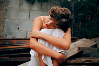 A woman in a white dress sits alone, conveying solitude and introspection. HD wallpaper