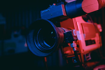 Artistic close-up of a vintage video camera lens in dramatic lighting. HD wallpaper