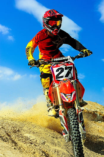 Motocross rider speeding on dirt track, showcasing skill and adrenaline. HD phone wallpaper