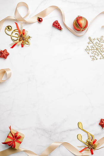 A charming top view of Christmas decorations with gold ribbons and ornaments on a marble background. HD phone wallpaper