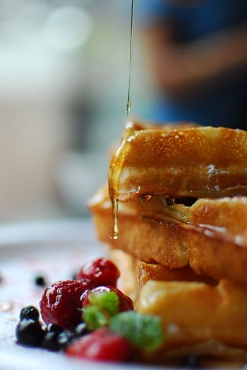 Syrup drips onto stacked waffles with fresh berries, a breakfast delight. HD phone wallpaper