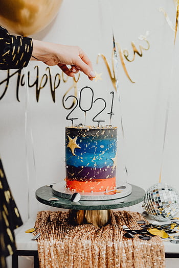 Charming New Year's cake decorated with colorful layers and 2021 sparkler topper, perfect for festive celebrations. HD phone wallpaper