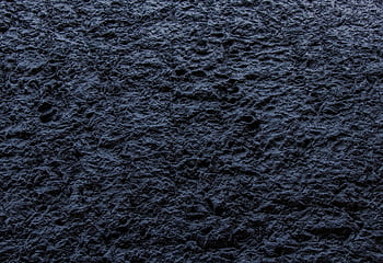 Close-up of a dark, rough textured stone surface providing an abstract background. HD wallpaper