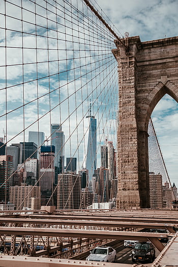 Iconic view of Brooklyn Bridge with Manhattan skyline and One World Trade Center in New York City. HD phone wallpaper
