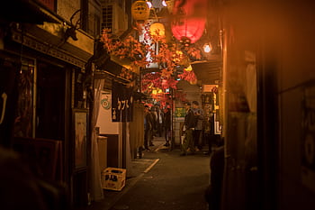 Bustling Tokyo street scene at night with paper lanterns and people. HD wallpaper