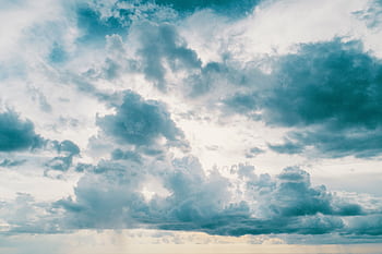 A breathtaking view of fluffy, dramatic clouds in a clear sky, ideal for nature backgrounds. HD wallpaper