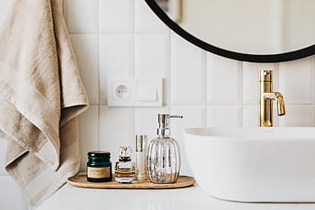A stylish bathroom sink with skincare products and accessories for modern living. HD wallpaper