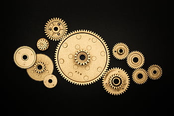 Golden gears on a black background representing industry and cooperation. HD wallpaper