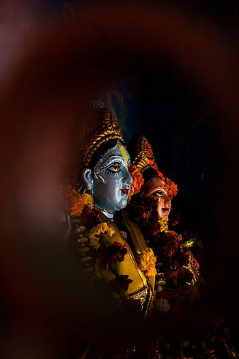Close-up of colorful and sacred Indian statues adorned with vibrant flowers, reflecting cultural and religious depth. HD phone wallpaper