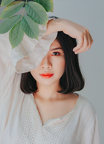 Serene portrait of a woman with leaves, perfect for beauty and nature themes. HD phone wallpaper