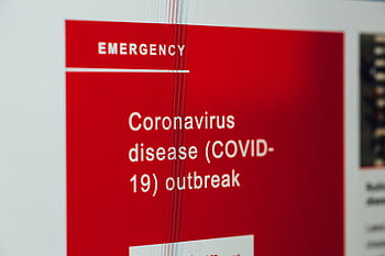 Close-up of a COVID-19 emergency alert message on a digital screen. HD wallpaper