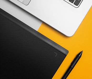 Overhead view of a laptop and graphics tablet on a colorful desk setup. HD wallpaper