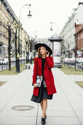 Fashionable woman in a red coat and black hat strolls through an urban street. HD phone wallpaper