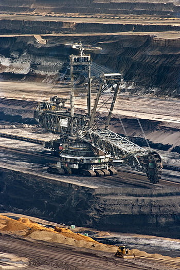 Large bucket wheel excavator operating in an open-pit mine with layered soil and coal. HD phone wallpaper