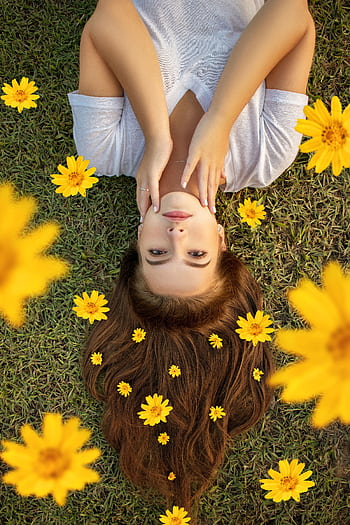 Upside down portrait of a woman lying on grass with yellow flowers in her hair. HD phone wallpaper
