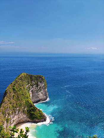 Breathtaking view of a cliff meeting the vibrant blue ocean in Balikpapan, Indonesia. HD phone wallpaper