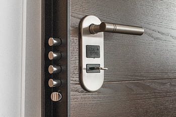 Metal door handle and lock system with key inserted, showcasing security features. HD wallpaper