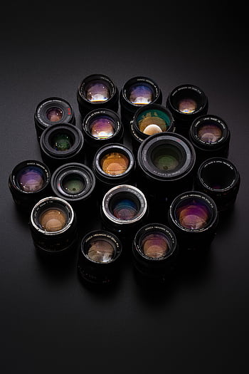 Diverse collection of camera lenses arranged on a sleek black surface. HD phone wallpaper