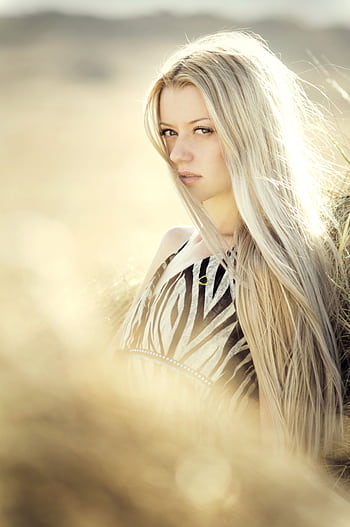 A captivating of a young woman with long hair in a sunlit outdoor setting. HD phone wallpaper