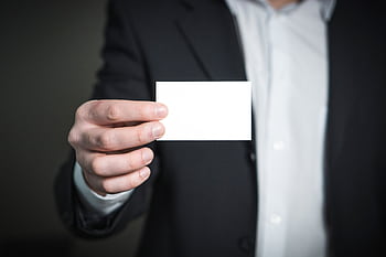 Professional holding a blank business card, ideal for personal branding or business contacts. HD wallpaper